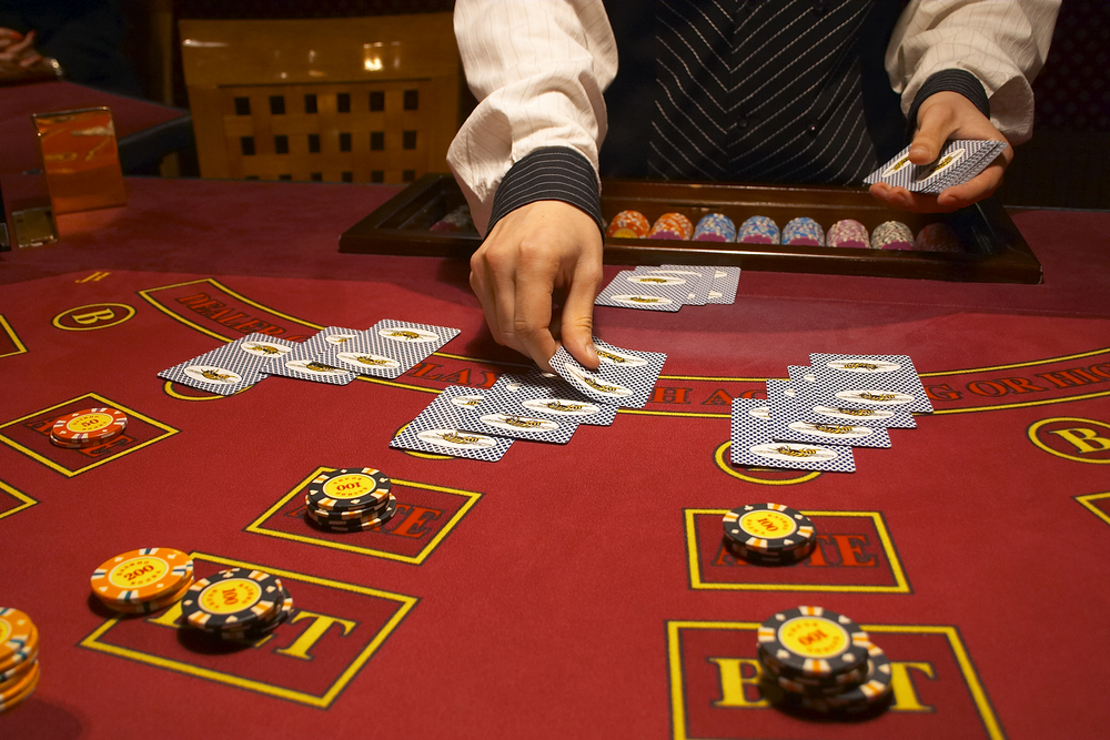 menggandakan blackjack - dealer menangani dua tangan di meja kasino
