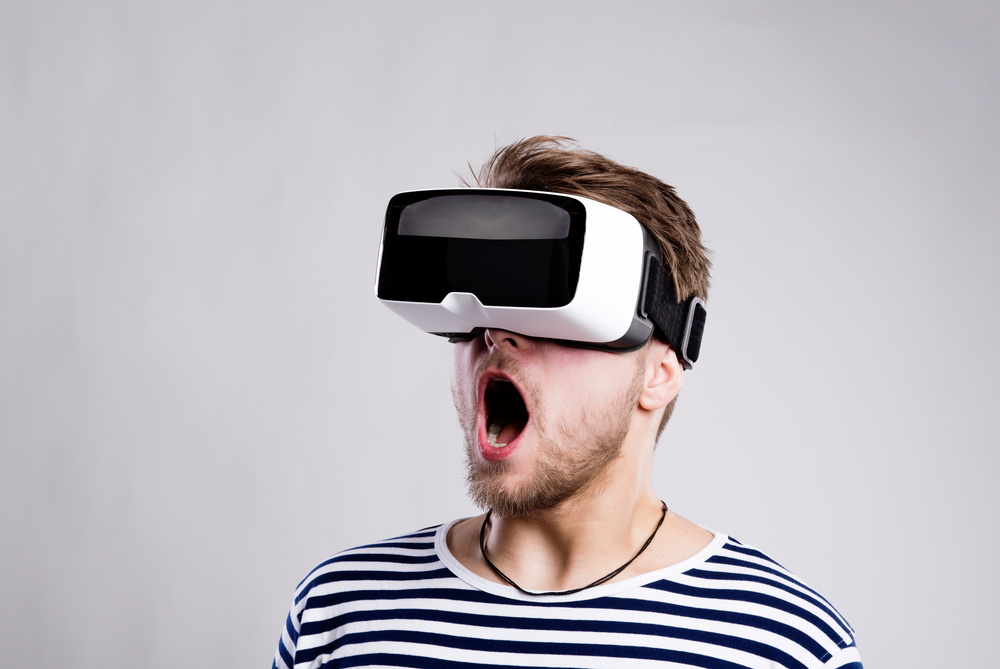 Man wearing virtual reality goggles. Studio shot, black backgroud